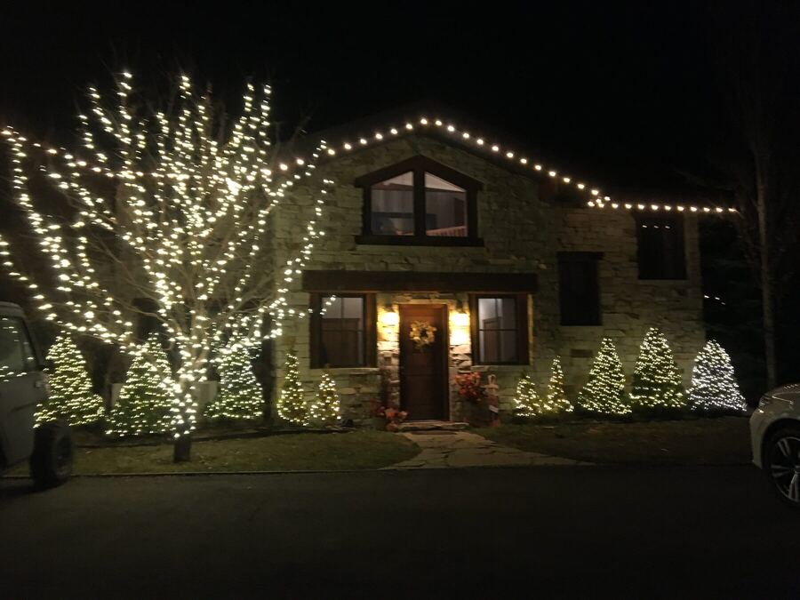 Stone house with a wrapped tree and a warm roofline