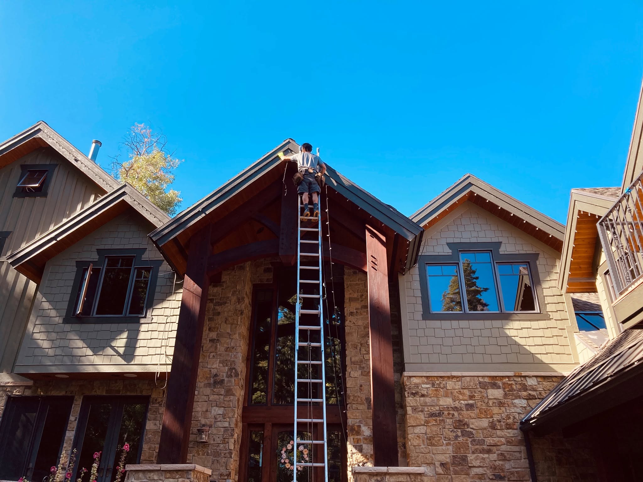 Ryan installing lights on a rooftop peak